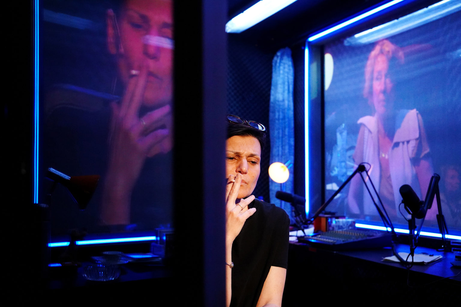 Vedrana Božinović fumant une cigarette devant des écrans
