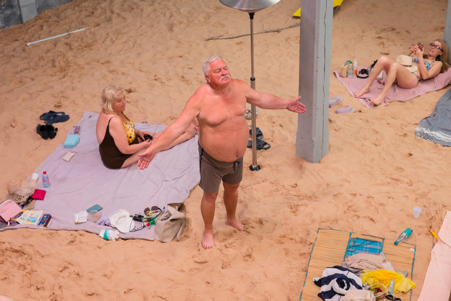Vieil homme debout sur la plage les bras écartés