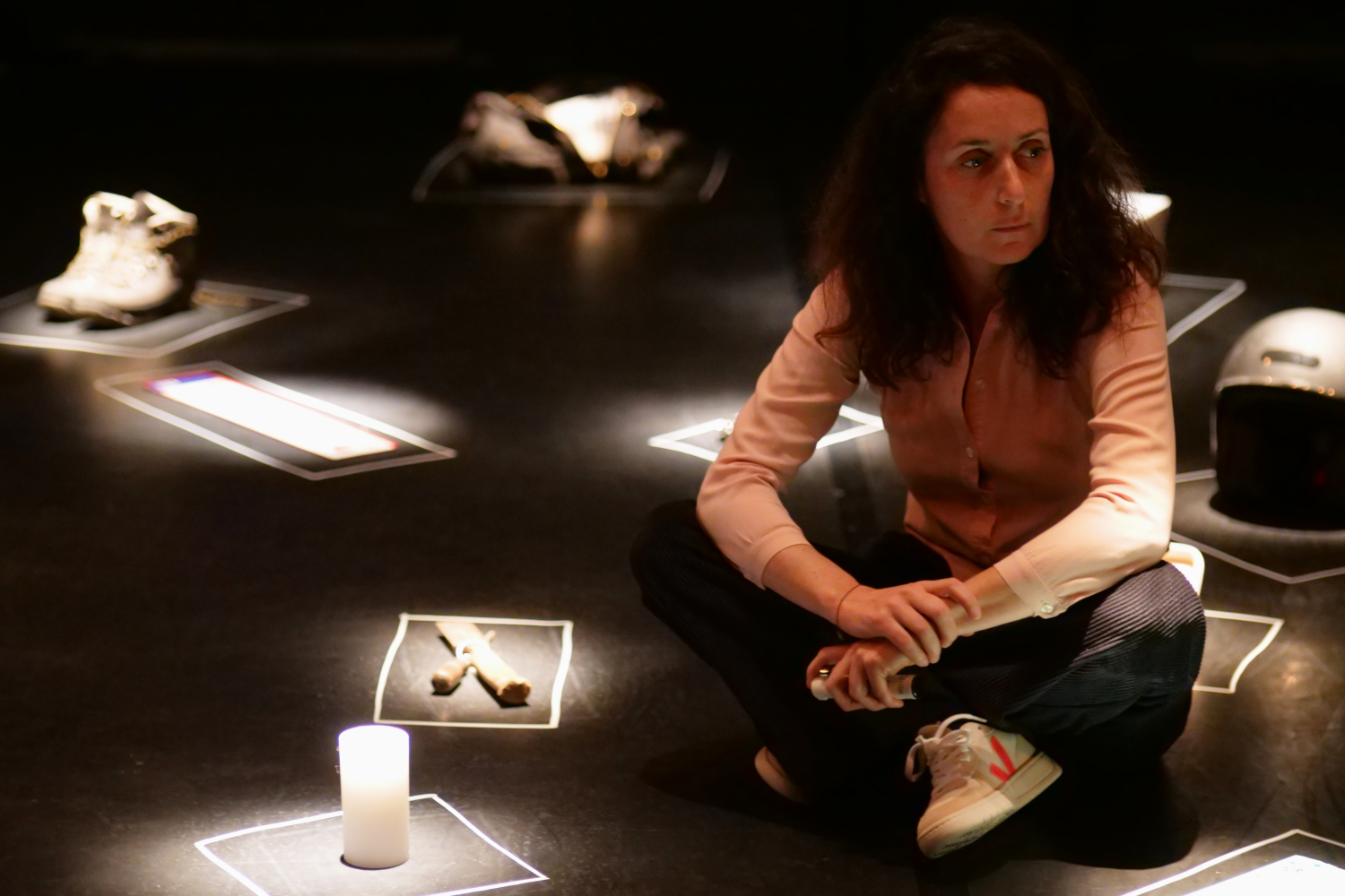 Jasmina Douieb assise sur le sol devant des objets