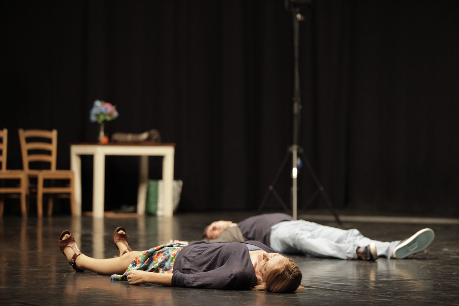 Comédien et comédienne allongés sur le sol