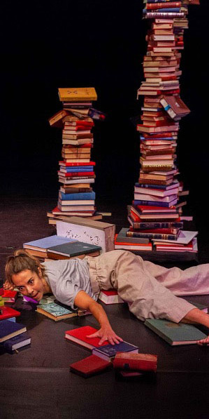 Deux danseurs sur le sol au milieu de livres