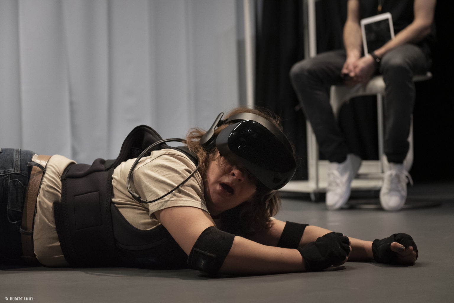 Une comédienne sur le sol avec un casque de VR
