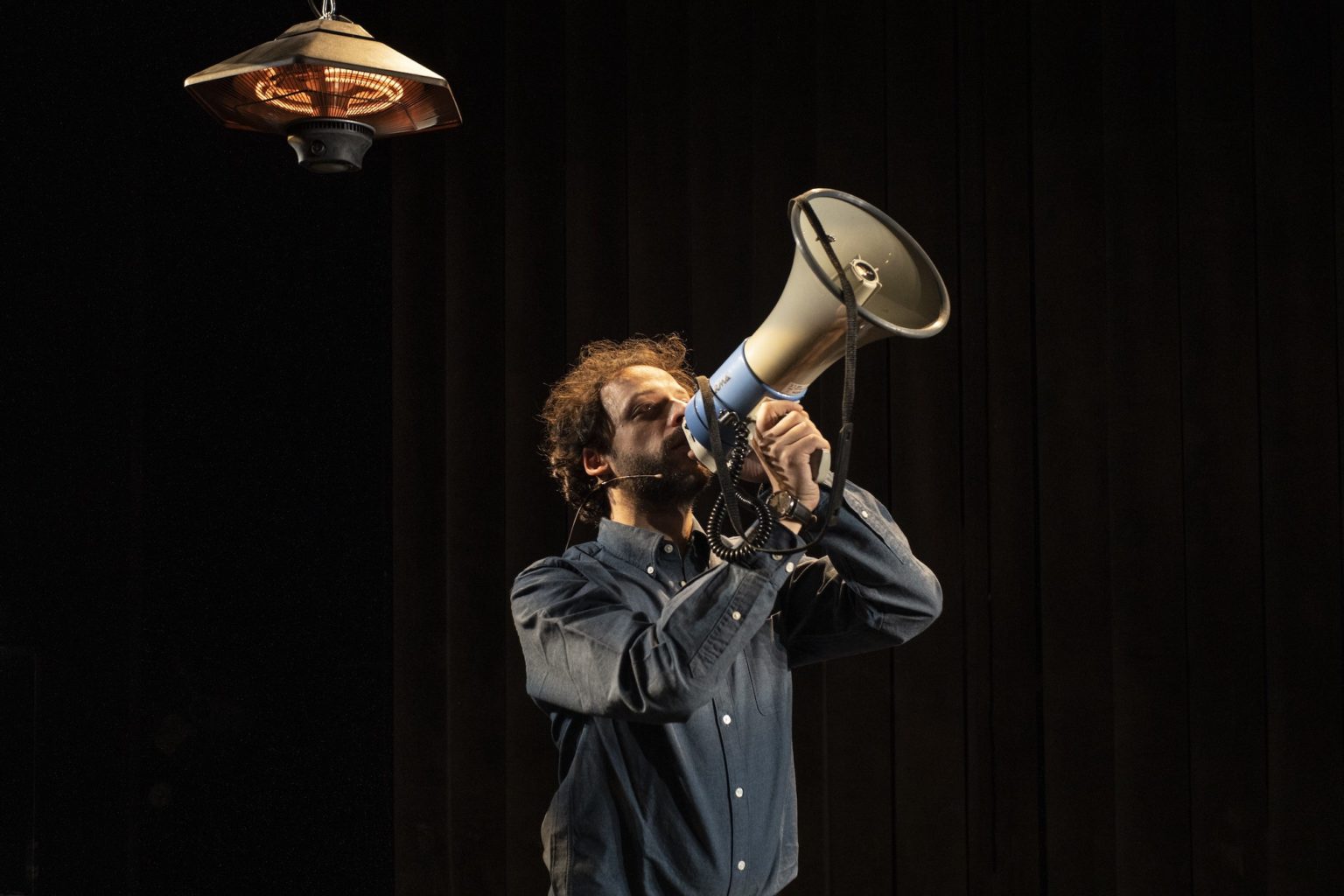 Photo du spectacle Il Capitale de Kepler-452 où l'on voit un acteur avec un mégaphone en mains
