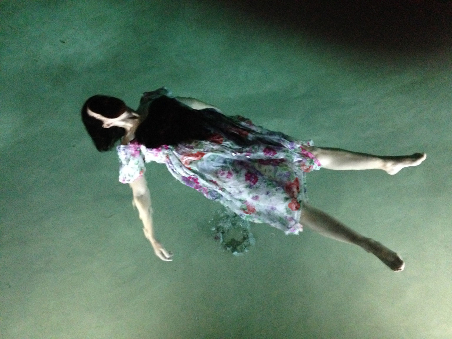 Le corps d'une femme, habillée et le visage caché, flotte sous l'eau