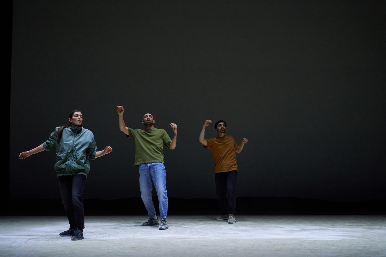 Photo du spectacle "Paysage" où l'on voit les 3 danseurs debout au milieu du grand plateau vide, comme s'ils allaient tomber.