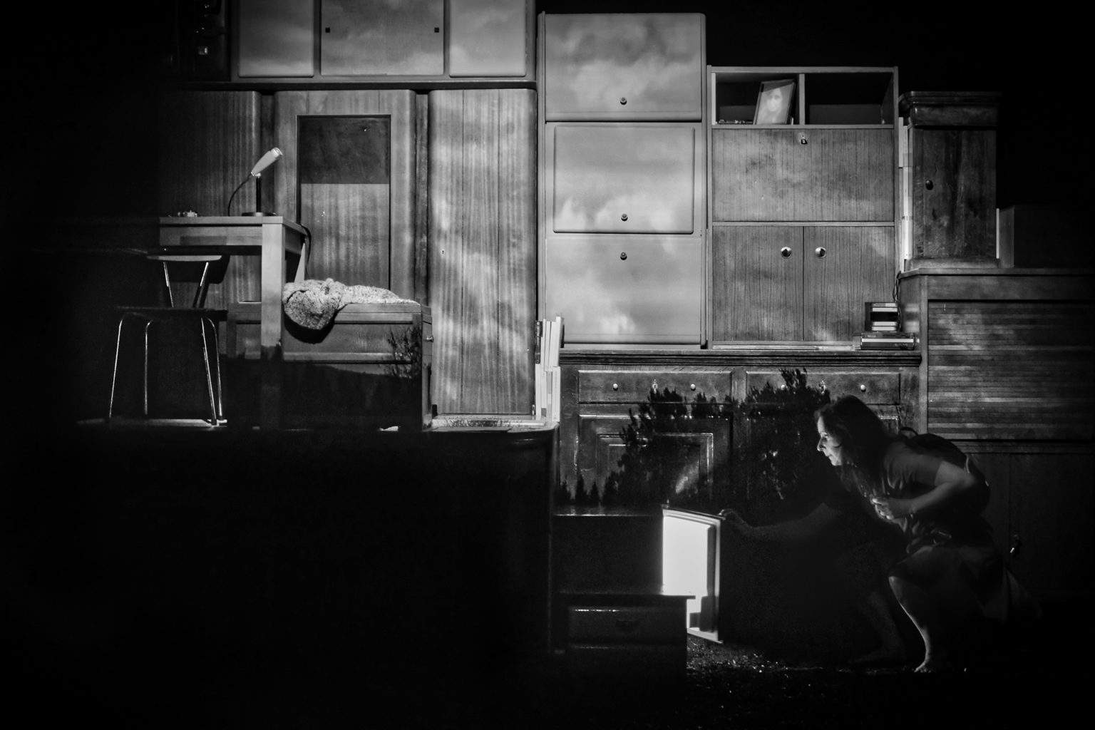Photo en noir et blanc où l'on voit Jasmina Douieb qui se penche devant un écran.
