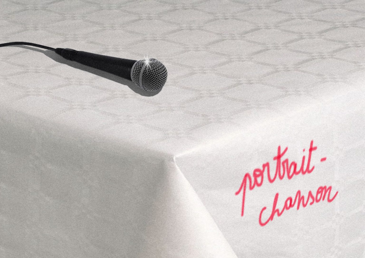 Sur une table avec une nappe blanche, on voit un micro et les mots "portrait-chanson"