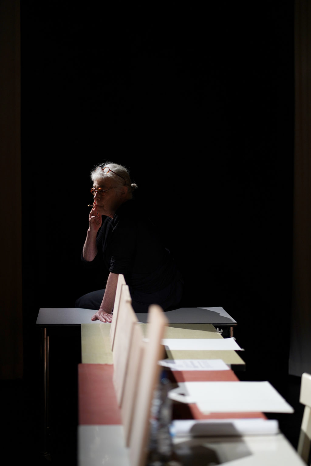 Françoise Bloch, dans la pénombre, fume une cigarette.