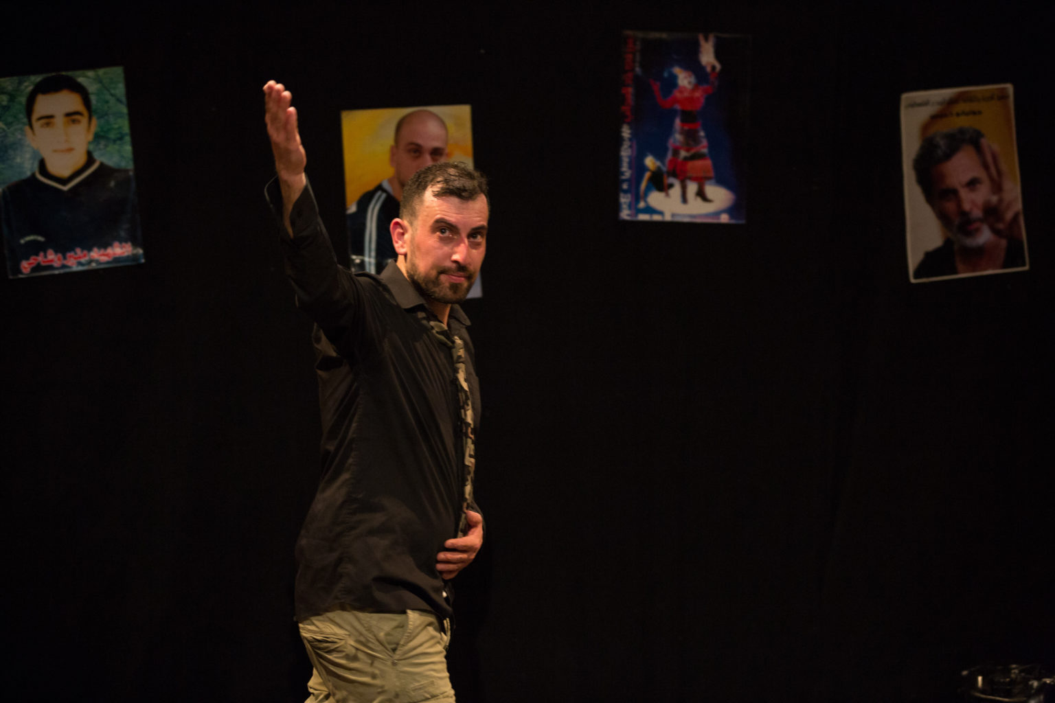 Photo d'Ahmed Tobasi sur scène levant le bras vers le public.