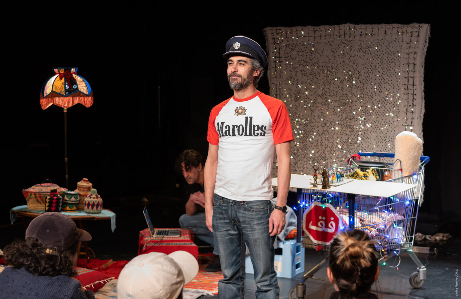 Othmane Moumen qui porte un t-shirt rouge et blanc avec l'inscription "Marolles". Il porte une casquette d'officier.