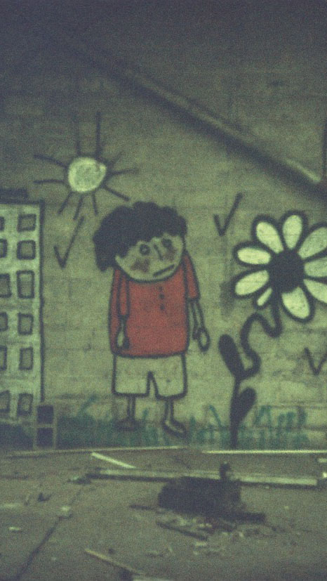 Fresque d'un enfant avec un t-shirt rouge accompagné d'un immeuble dessiné la gauche et d'un tournesol dessiné sur la droite.