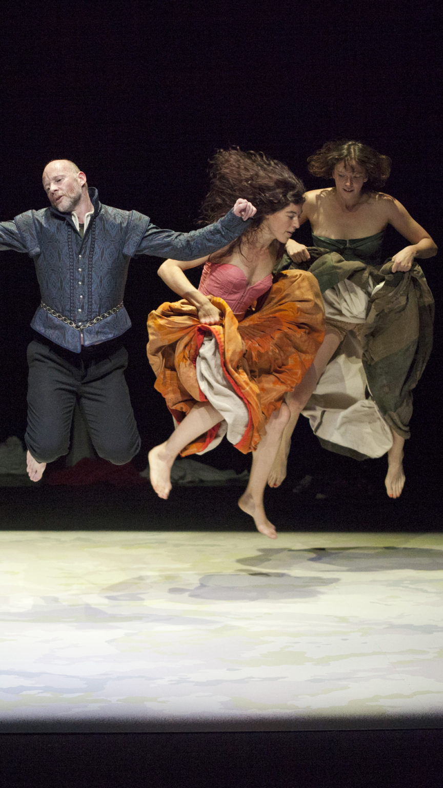 Un groupe de danseurs·euses costumés sautent en l'air sur scène.
