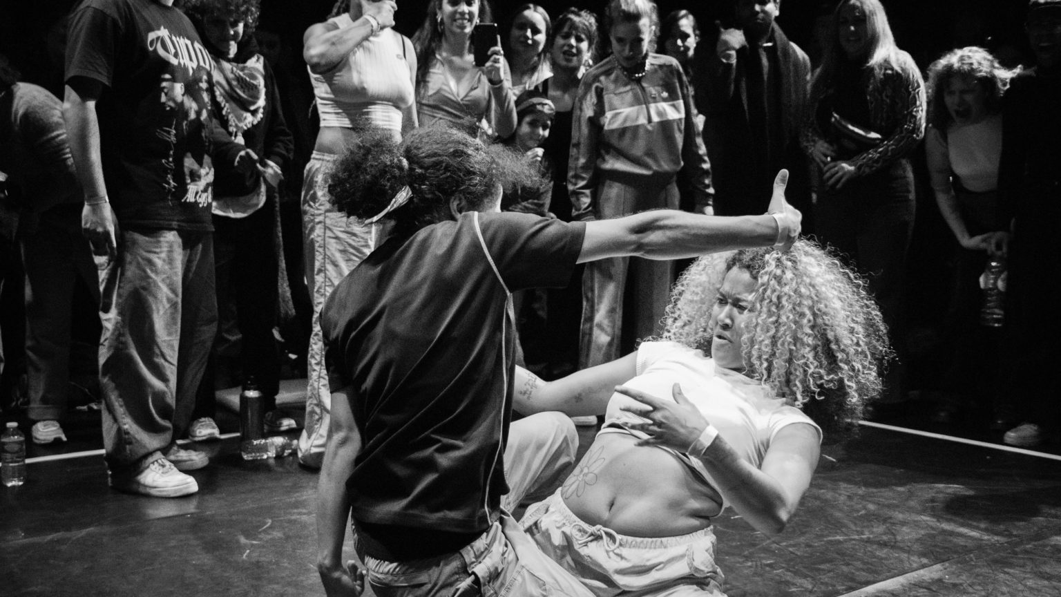 Photo en noir et blanc représentant des personnes qui font une battle de danse