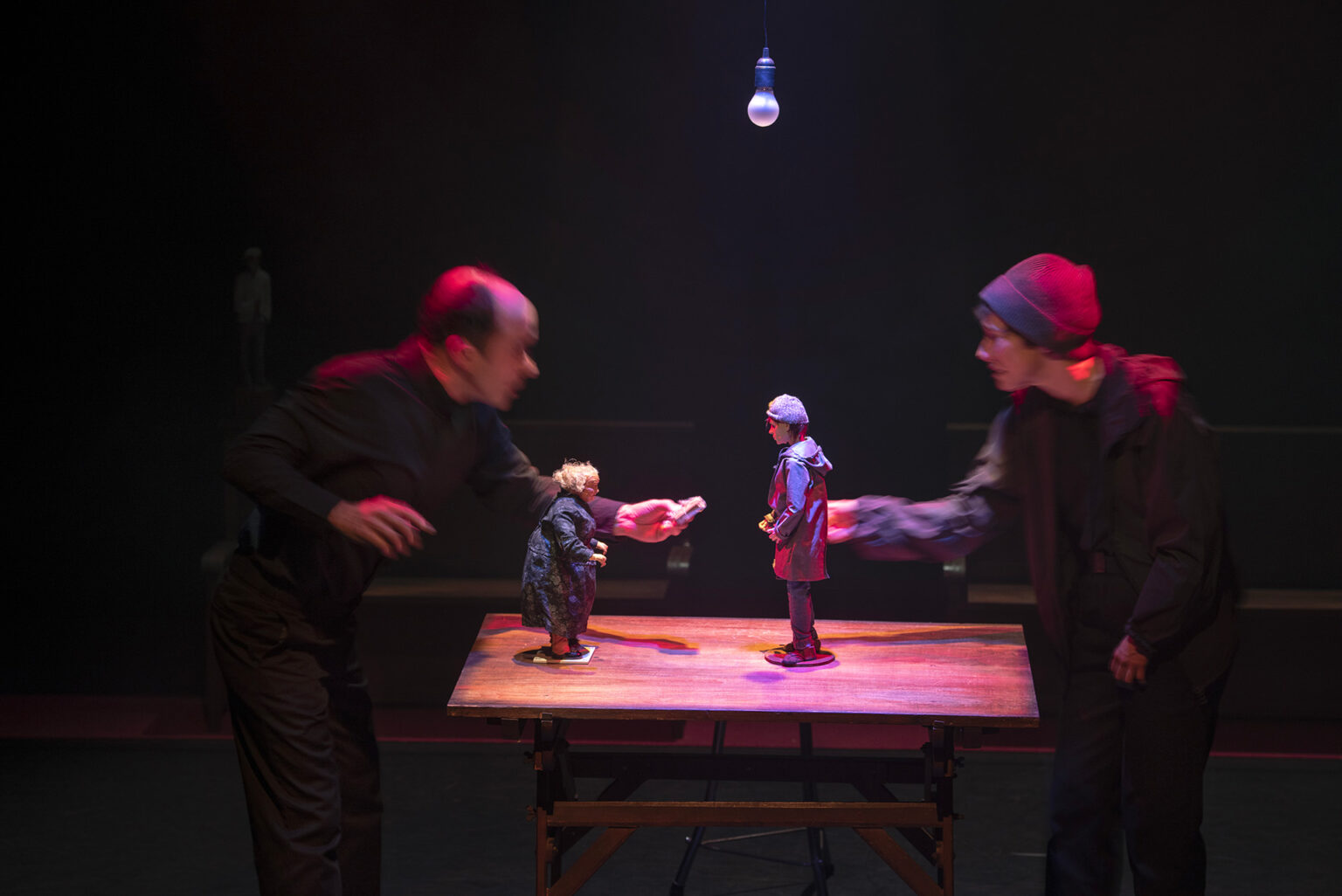 L'acteur Cyril Briand et l'actrice Marie Delhaye se font face derrière une table. Ils sont habillés de noir. Ils tendent la main l'un vers l'autre. Deux figurines sont sur cette table. Celle d'un jeune garçon, certainement Raskolnikov, et celle d'une veille dame, certainement l'usurière.