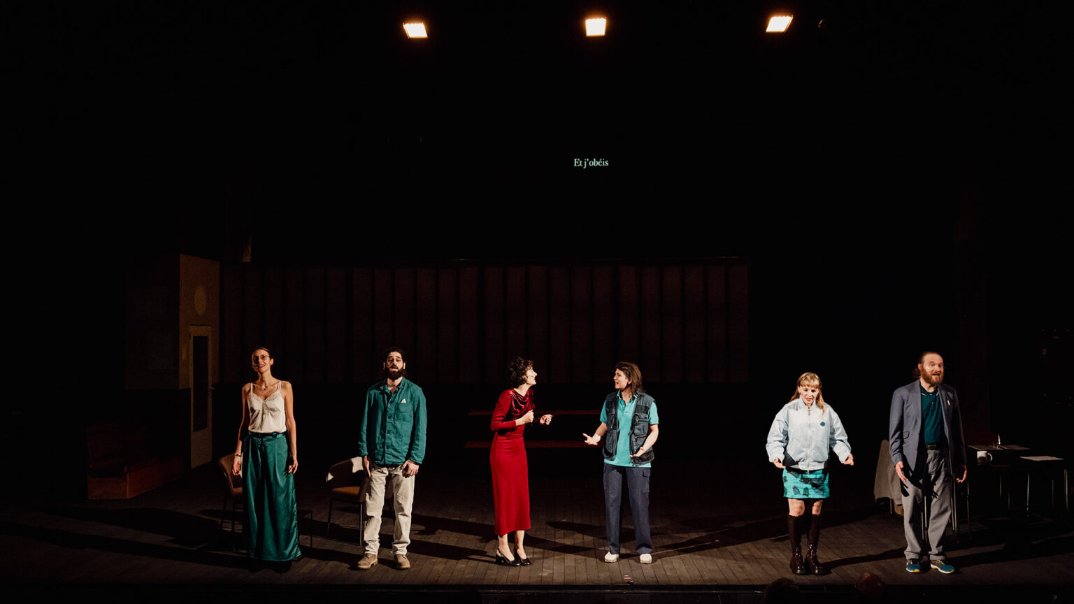 Les cinq chanteurs de la chorale et la cheffe de choeur sont alignés, à l'avant-scène