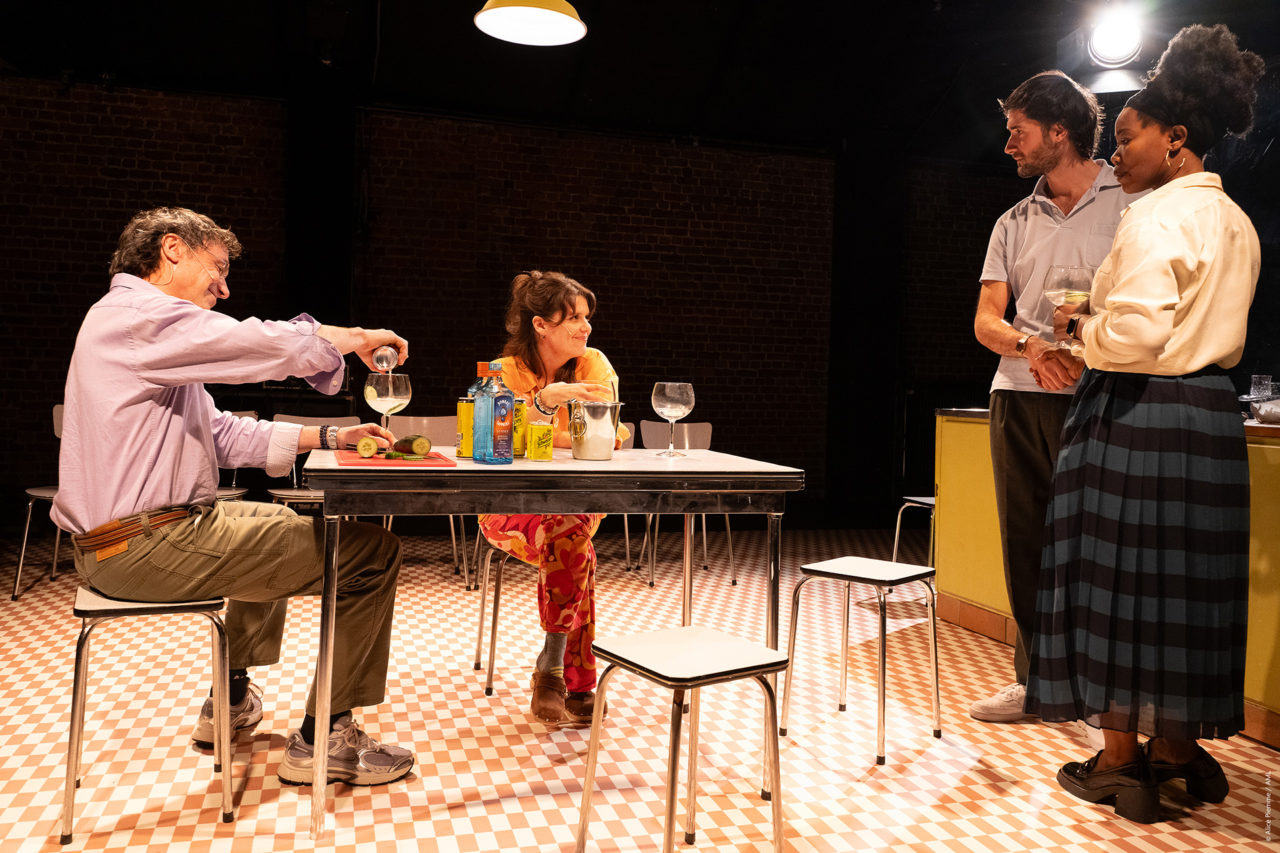 2 couples hétéro discutent. Deux sont attablés autour d'une table et deux autres sont debout. Ils boivent du gin.