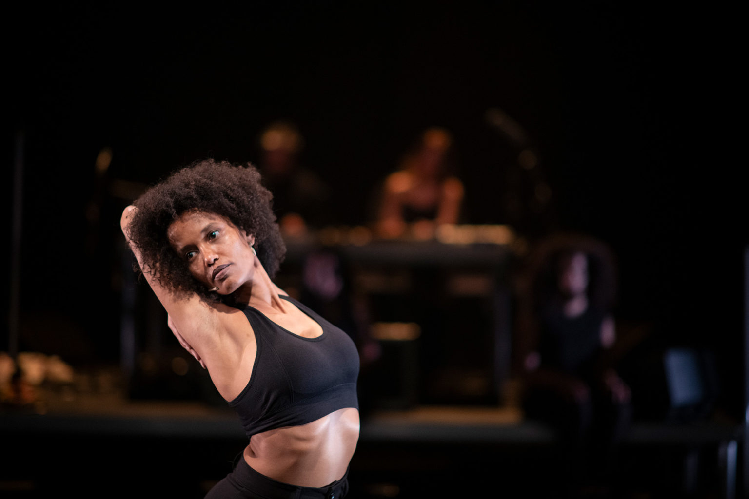 L'interprète Tenei Ahmad danse. Elle est cambrée, les bras derrière sa tête.