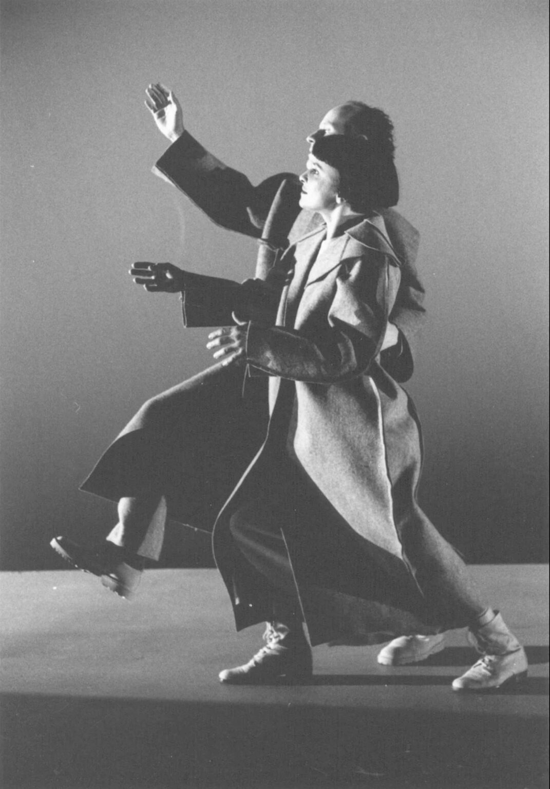 Photo en noir et blanc de deux personnes qui marchent côte à côte et portent un grand manteau d'hiver.