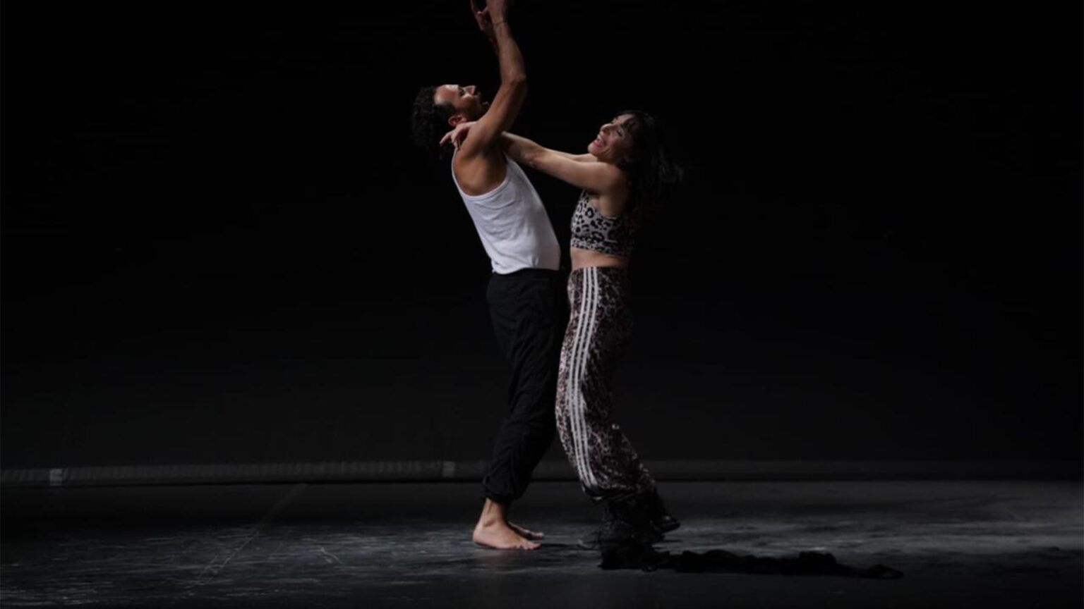 Marina danse en serrant dans ses bras un homme qui tend les bras au ciel.