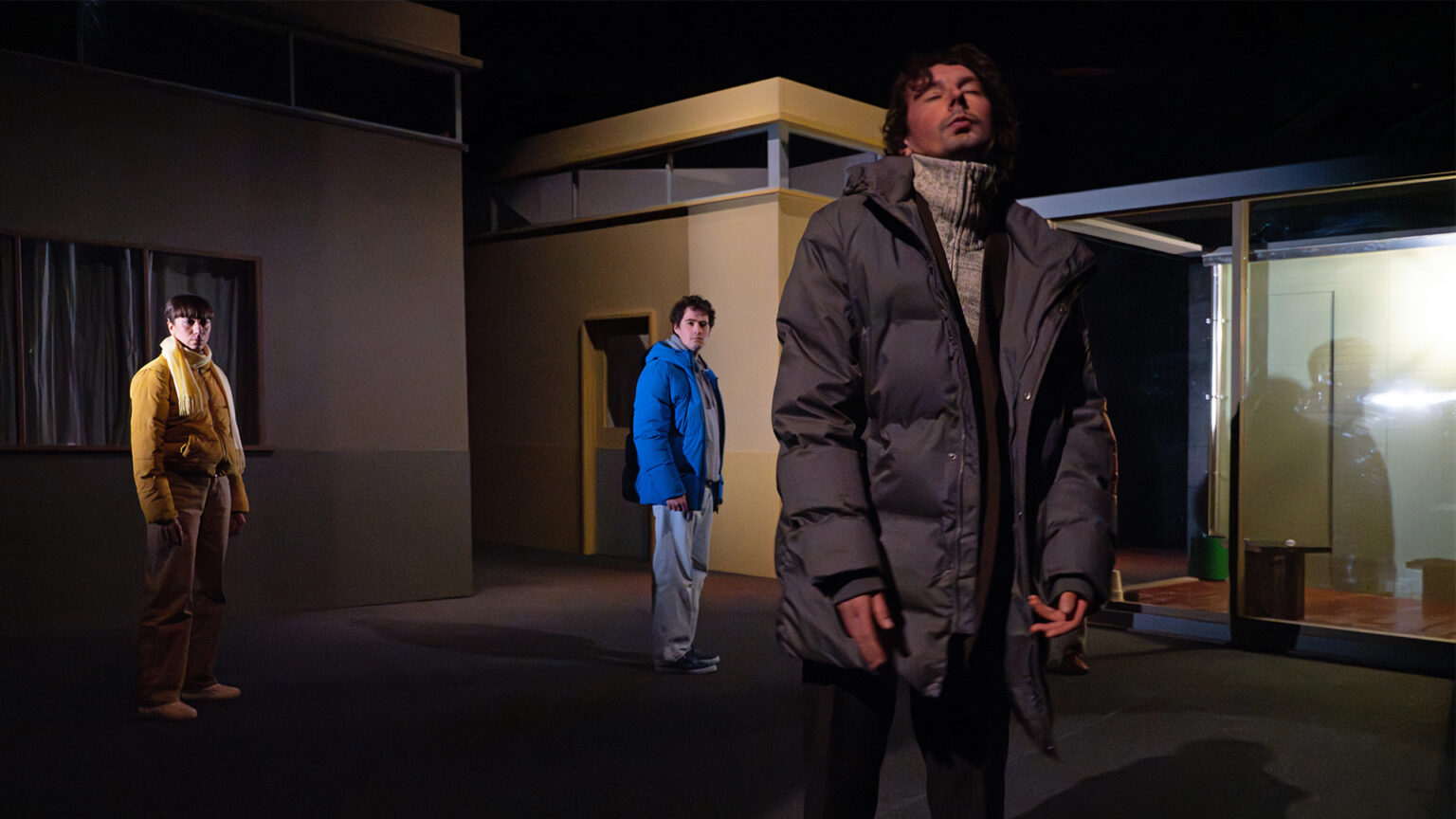 Dans les couloirs de l'université, Salomon Tyler se tient devant les autres (Marion Ménan et Tim Privat) et ferme les yeux.