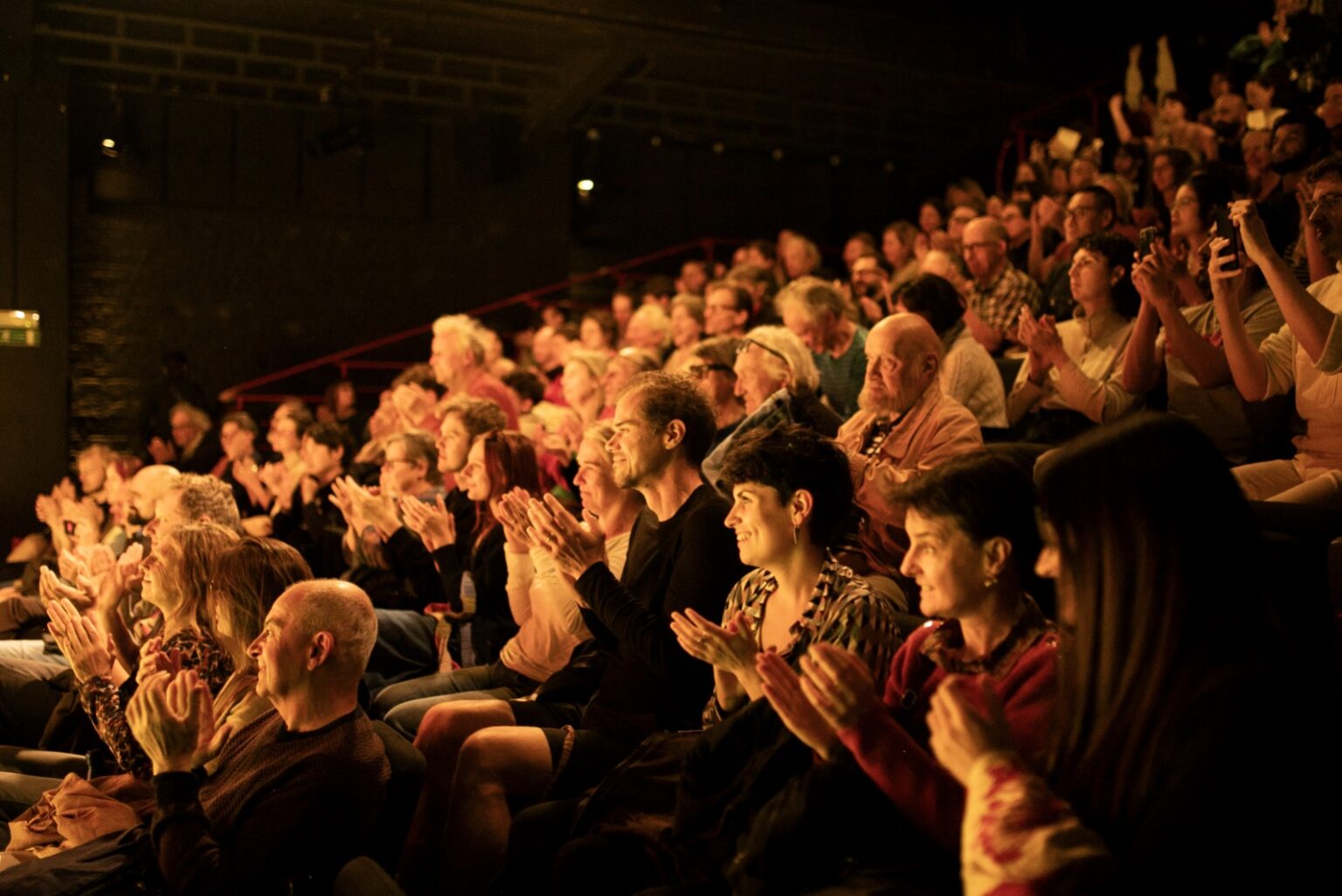 Public de profil, installé dans la salle du Théâtre Les tanneurs et occupé à applaudir