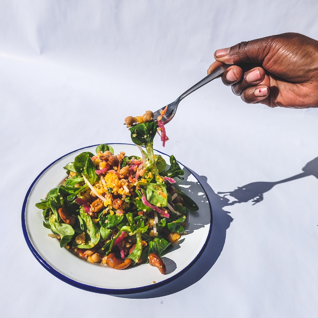 Un plat élaboré par un employé de Refoodgees. Une main tient une fourchette et pioche dans l'assiette (sorte de salade).